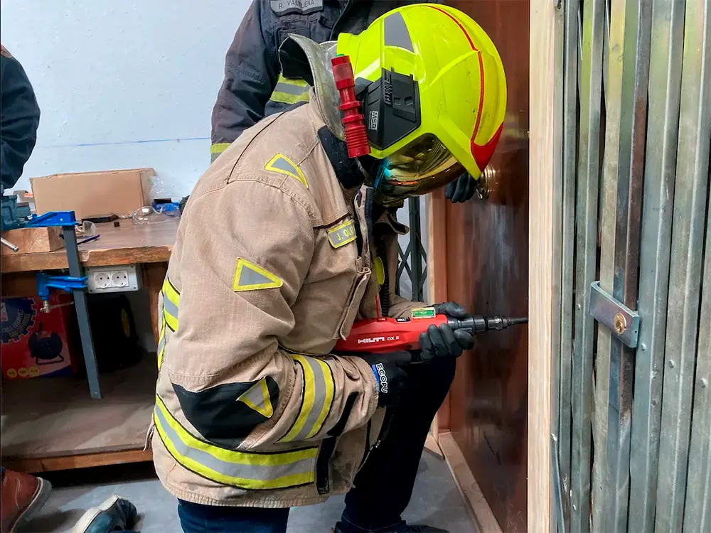 Efectivo del cuerpo de bomberos equipado con EPIs ejecutando una maniobra de apertura técnica y breaching mecánico sobre una cerradura utilizando herramientas del Método Katana.